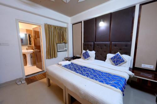 a bedroom with a large bed and a large mirror at Family Hotel Opera Near IGI Airport in New Delhi