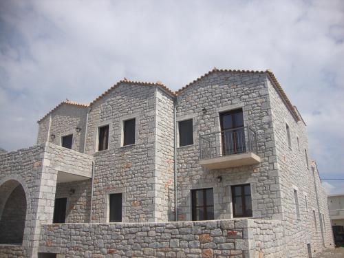 a large stone building with a balcony on it at Koukouri Suites in Areopolis