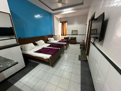 Habitación con 2 camas y pared azul en New Royal Hotel, en Nueva Delhi