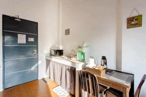 a kitchen with a sink and a table with chairs at Kua's Pad Tagaytay in Tagaytay