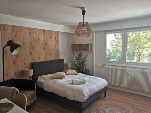 une chambre avec un lit et une grande fenêtre dans l'établissement Marnesia - Studio avec vue sur les quais, à Strasbourg