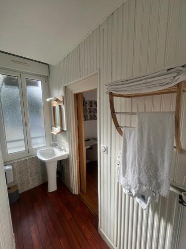 a bathroom with a sink and a white towel at Le petit Montmartre in Dinard