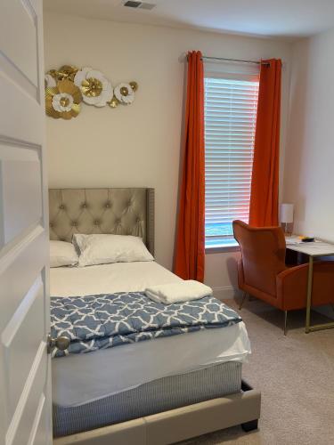 een slaapkamer met een bed, een stoel en een raam bij Exotic Room in Hampton