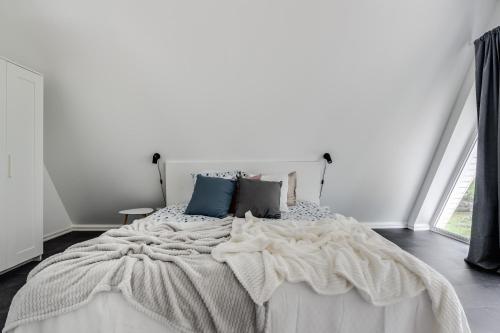 a bedroom with a large white bed with pillows at Newly built westcoast dream home in Ängelholm