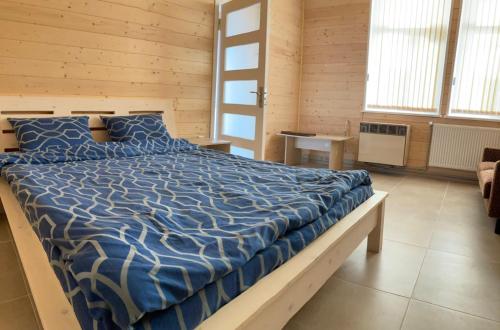 a bedroom with a bed with a blue comforter at Апартаменти на Пекарській in Kolomiya