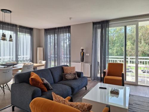 a living room with a blue couch and a table at Duinhof in Cadzand-Bad