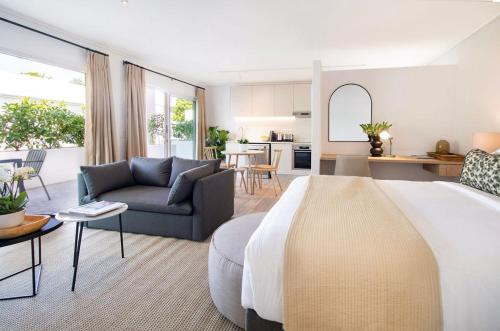 a bedroom with a large bed and a living room at Middedorp Apartments in Stellenbosch