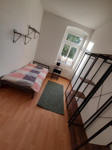 a room with a bed and a staircase with a window at Mimalou möbliertes Apartment in Chemnitz in Chemnitz