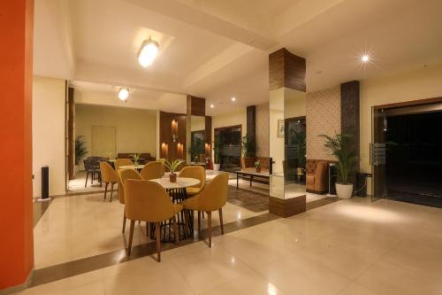 a dining room and living room with a table and chairs at IRA by Orchid, Nashik in Nashik