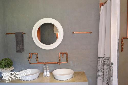a bathroom with a sink and a mirror at Whispering Pines in Dullstroom