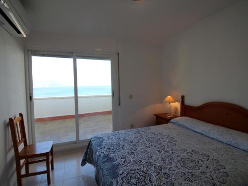 a bedroom with a bed and a view of the ocean at LLANÇÀ 11 ÀTIC - Ático en primera línea de mar, gran terraza y piscina comunitaria - ES-228-60 in Port de la Selva