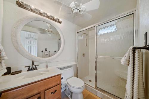 a bathroom with a toilet and a sink and a mirror at Nani Kai Hale A209 in Kihei