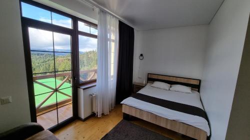 a bedroom with a bed and a large window at SPA hotel Villa Sofia in Yablunytsya