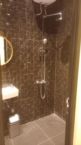 a black tiled bathroom with a shower and a toilet at Rumah WJ rooms and suites in Uluwatu