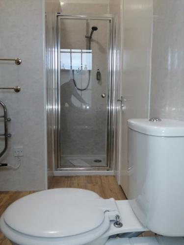 a bathroom with a shower and a white toilet at Cumberland Hotel in Edinburgh