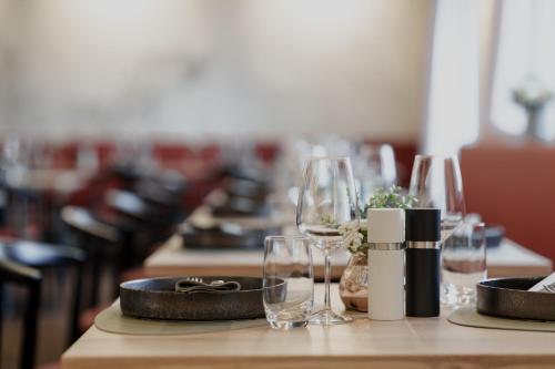 a long wooden table with glasses and napkins on it at Kloster by b-smart in Schaan