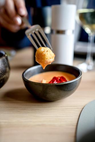 a person eating a piece of food with a fork at Kloster by b-smart in Schaan