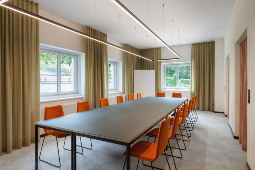 a conference room with a long table and chairs at Kloster by b-smart in Schaan