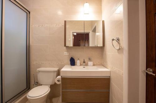 a bathroom with a toilet and a sink and a mirror at Airport View 3-Bed Villa in Cupecoy
