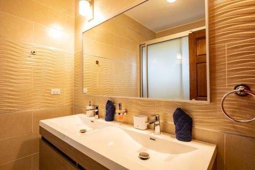 a bathroom with a sink and a mirror at Airport View 3-Bed Villa in Cupecoy