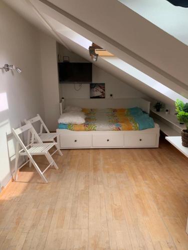 1 dormitorio con 1 cama y 1 silla en el ático en Nid d amour sous les toits, en Nogent-sur-Marne