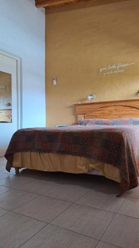 1 cama en un dormitorio con cabecero de madera en Del Solar en San Rafael