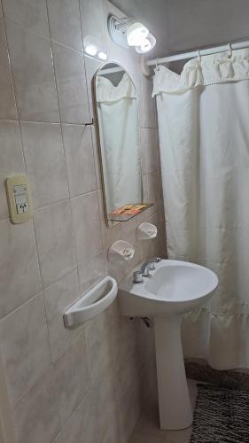 Baño blanco con lavabo y espejo en Del Solar en San Rafael
