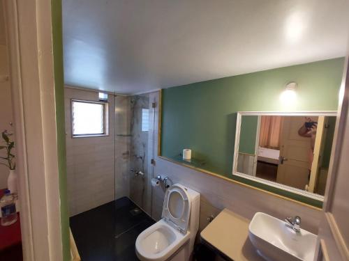 a bathroom with a toilet and a sink and a mirror at Angels Resort in Porvorim