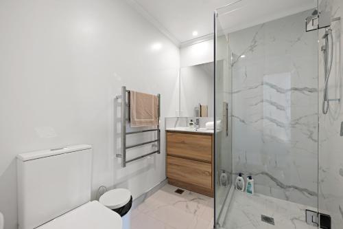 a bathroom with a shower and a toilet and a sink at New towhouse walk to the hospital & CBD & the Lake in Hamilton