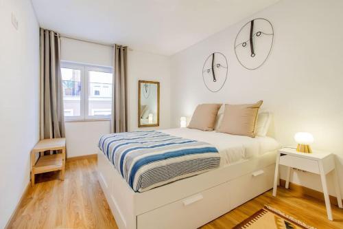 リスボンにあるPríncipe Real Sunny Apartmentの白いベッドルーム(ベッド1台、窓付)
