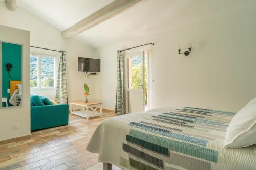 a bedroom with a bed and a blue couch at Logis Hôtel Restaurant Le Pradinas in Anduze