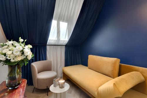 a living room with a couch and a vase of flowers at Hôtel Artemisia Montmartre in Paris