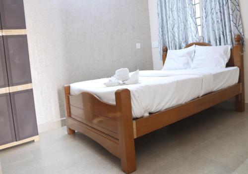 Pradee Queen Resorts في Tiruvallūr: غرفة نوم بسرير ذو شراشف ووسائد بيضاء