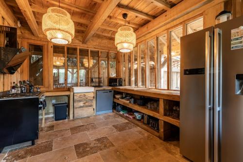 Il comprend une grande cuisine avec des murs et un plafond en bois. dans l'établissement Villa Chan-Ly Été, à Lacanau