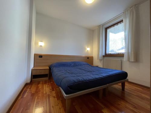 a small bedroom with a bed and a window at 081 Trilocale Baldino, Pinzolo in Pinzolo