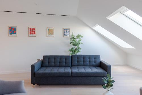 - un canapé bleu dans le salon avec plafond dans l'établissement Zen Sanctuary - Soho - by Frankie Says, à Londres