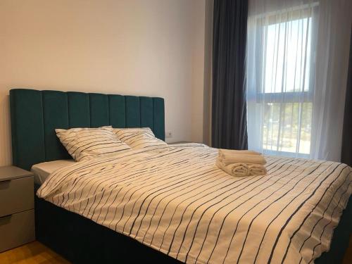 1 cama con cabecero verde en un dormitorio en UpNorth Home, en Bucarest