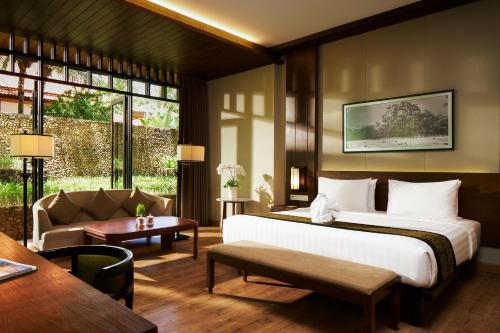 a hotel room with a bed and a couch at eL Hotel Banyuwangi in Banyuwangi