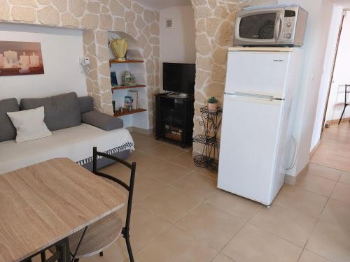 - un salon avec un canapé et un réfrigérateur dans l'établissement Appartement 4 Pers VERGEZE, à Vergèze