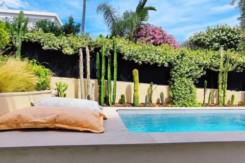 un lit à côté d'une clôture avec des plantes et une piscine dans l'établissement FRGK 