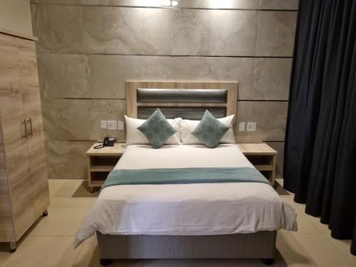 a bedroom with a large bed with blue pillows at Bayside Hotel 116 West Street in Durban