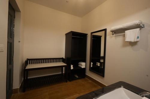 a bathroom with a sink and a mirror and a bench at Anandam - A Luxury Resort in Udaipur in Udaipur