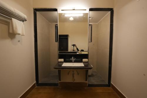a bathroom with a sink and a large mirror at Anandam - A Luxury Resort in Udaipur in Udaipur