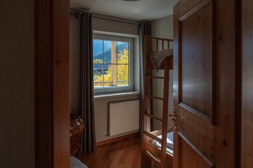a bedroom with a bunk bed and a window at Boutique Hotel Bellevue Lermoos in Lermoos