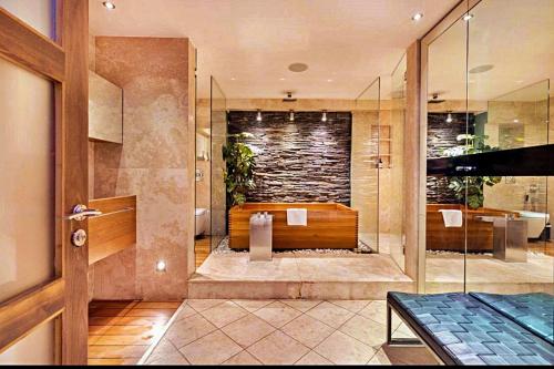 a bathroom with a bath tub with a stone wall at Finest Retreats - King Charles House in London