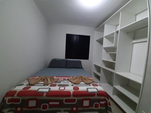 a small bedroom with a bed and a book shelf at LA00-Bertioga, Próximo ao SESC, Riviera, Vista Linda, Indaiá in Bertioga