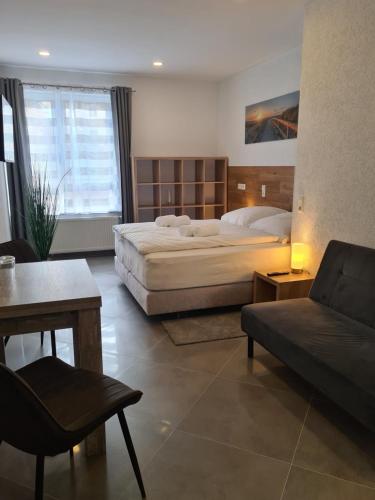 a hotel room with two beds and a couch at WellandHome Aalen - 6 Rooms in Aalen