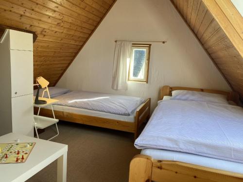 a bedroom with two beds and a table with a desk at Dreimädelshaus in Uhldingen-Mühlhofen