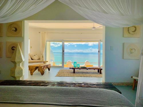 Villa Santorini في فيلانكولوس: غرفة نوم مع سرير وإطلالة على المحيط