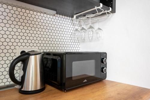 a black microwave sitting on top of a counter at White Wolf House Hostel & Apartments in Prague
